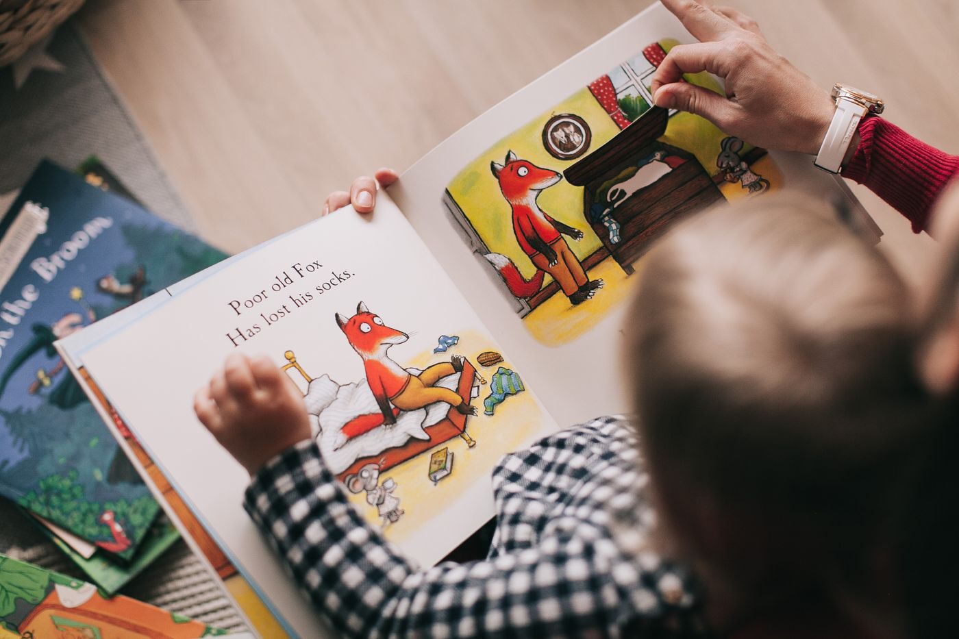 A child and adult reading an illustrated storybook together